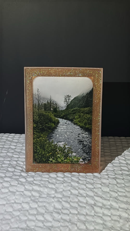Custom glittery epoxy framed photo of a river in the mountains.