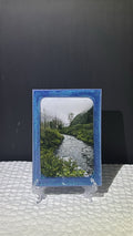 Custom glittery blue epoxy framed photo of a river in the mountains.