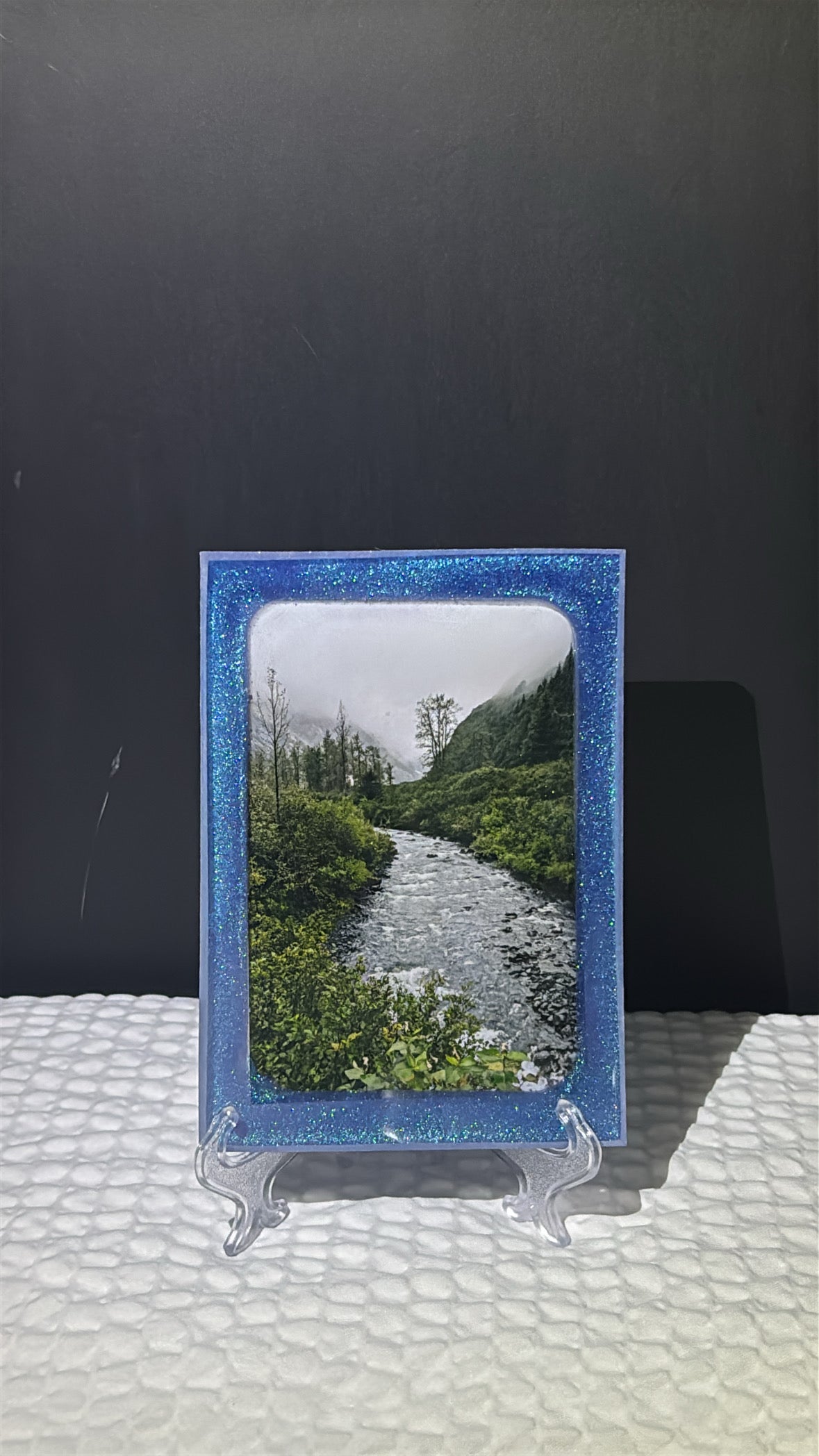 Custom glittery blue epoxy framed photo of a river in the mountains.