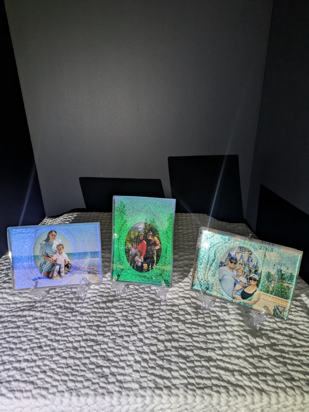 Group of three custom glittery epoxy photo frames in blue and green, displaying various family portraits